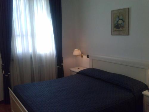 a bedroom with a blue bed and a window at La Vela in Viadana