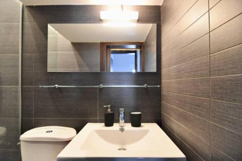 a bathroom with a sink and a toilet and a mirror at Modern apartment in the heart of the city in Larisa
