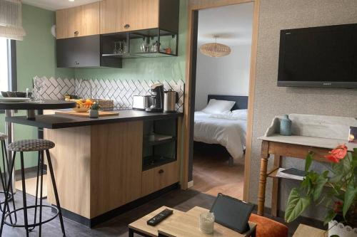 une chambre avec une cuisine et une chambre avec un lit dans l'établissement Le Clos des Feugrais, à Saint-Aubin-lès-Elbeuf