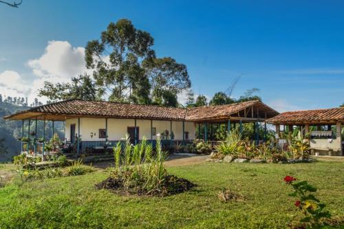 a house with a garden in front of it at Hostal rural la montaña alquiyapura in Salento