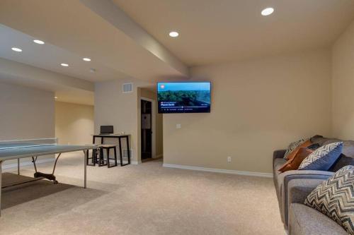 a living room with a couch and a tv on the wall at Large Brand-New Home Close to Lake & Mountains in Monument