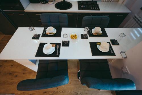 einen weißen Tisch mit Tellern und Servietten darauf in der Unterkunft View Apartament in Tulcea