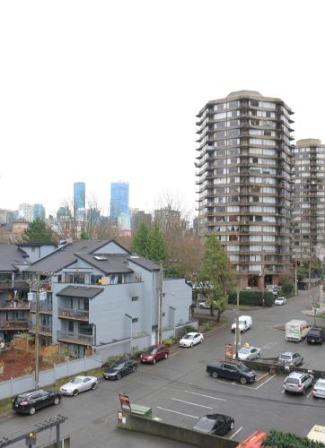 a parking lot with cars in a city with tall buildings at Best Western Plus Sands in Vancouver