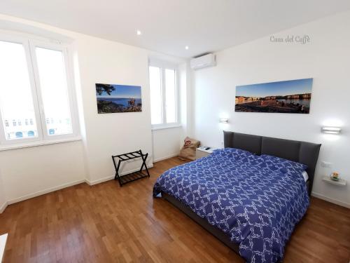 a bedroom with a bed with a blue comforter at Casa del Caffè in Trieste