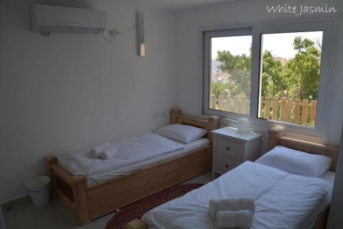 Un ou plusieurs lits dans un hébergement de l'établissement Jasmin Suites