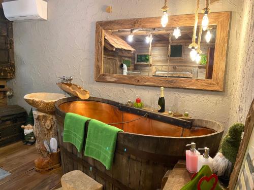 a wooden bath tub in a bathroom with a mirror at URBAN PIC NIC in Piazza Brembana
