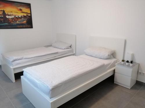 2 camas en una habitación con paredes blancas en Apartment EG, en Oststeinbek