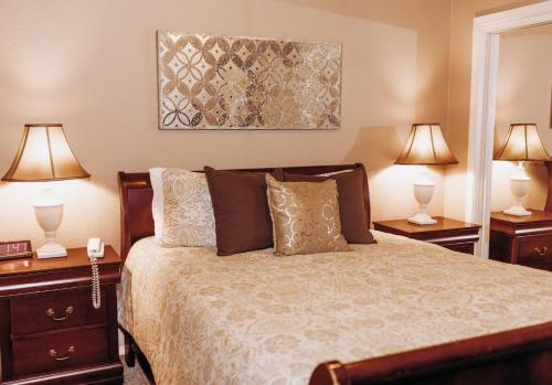 a bedroom with a bed with two night stands and two lamps at Pacific Inn Motel in Forks