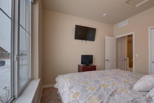 a bedroom with a bed and a tv on the wall at Large Brand-New Home Close to Lake & Mountains in Monument