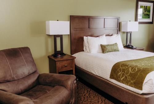 a hotel room with a bed and a chair at Pacific Inn Motel in Forks