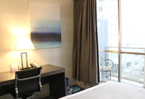 a hotel room with a desk and a bed and a window at Best Western Plus Sands in Vancouver