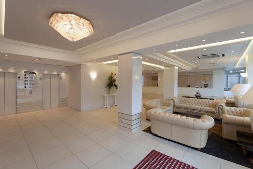 a lobby with couches and a waiting room at Hôtel Paradis in Lourdes