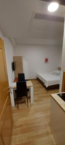 a room with a bed and a desk and a table at Apartmani Barka in Neum