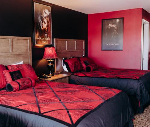 a bedroom with two beds and a red wall at Pacific Inn Motel in Forks