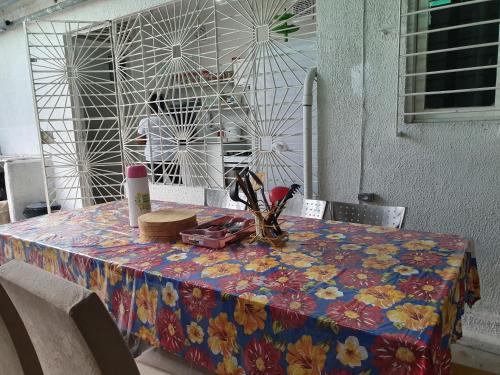 a table with a flowered table cloth on it at Casa da Esquina Pousada in Recife