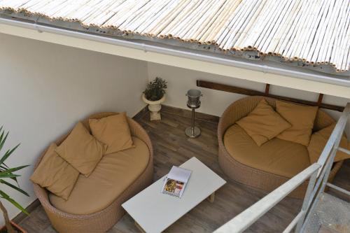 a living room with two chairs and a table at The Old Bakery in Cagliari