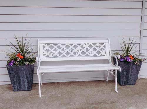 a white bench sitting next to two potted plants at Pacific Inn Motel in Forks