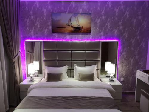 a bedroom with a large bed with purple lighting at Makarem Hotel Apartment in Riyadh