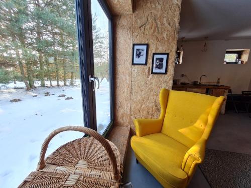 a yellow chair in a room with a window at Siedlisko Bolek in Nadrybie