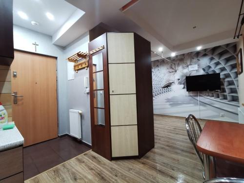 a room with a dining table and a tv in it at APARTAMENT CIEŃ GIEWONTU in Zakopane