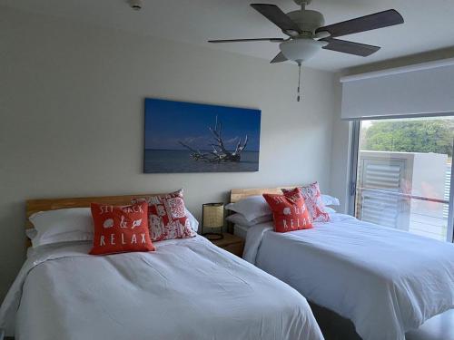 1 dormitorio con 2 camas y ventilador de techo en Azuero Lodge: Luxury Beachfront condo- Playa Venao, en Playa Venao