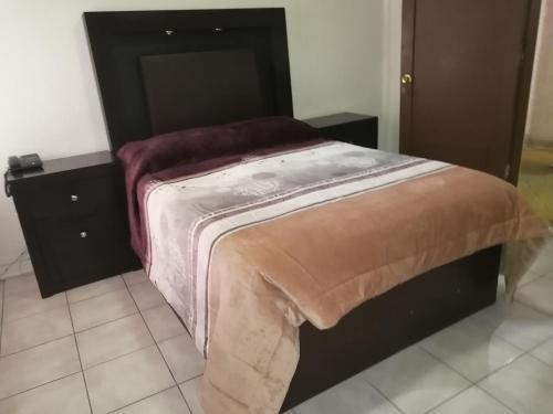 a bed in a room with two night stands at HOTEL BAEZA in Delicias