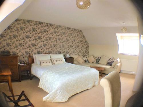 a bedroom with a bed and a couch at Hartpury B&B in Hartpury