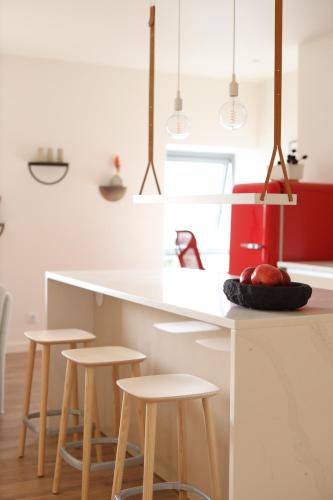 a kitchen with a white counter and stools at Three House Hotel in Funchal