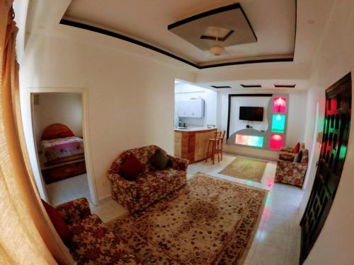 a living room with two chairs and a bedroom at Tara Apartments in Luxor