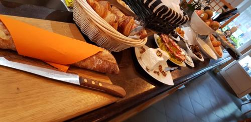 a counter with bread and cheese and a knife at Savoy Hotel & Restaurant in Saint-Michel-de-Maurienne