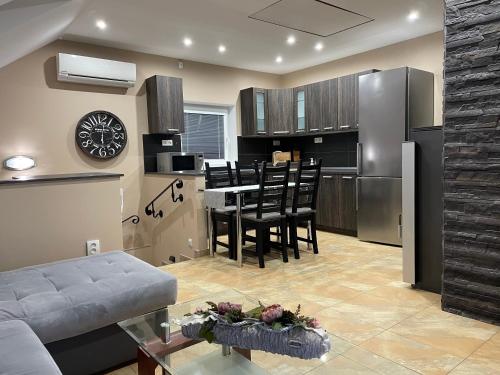 eine Küche und ein Wohnzimmer mit einem Tisch und einem Kühlschrank in der Unterkunft Apartmány Diana in Dunajská Streda