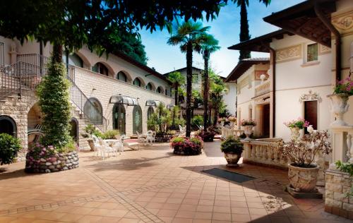 einen Innenhof eines Gebäudes mit Blumen und Pflanzen in der Unterkunft Park Hotel Ville Montefiori in Gardone Riviera