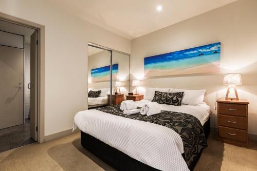 a bedroom with a large bed with a nightstand and a bed sidx sidx sidx at Absolute Collins Apartments in Melbourne