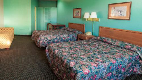 twee bedden in een hotelkamer met blauwe muren bij Red Horse Motel Dayton Moraine in Dayton