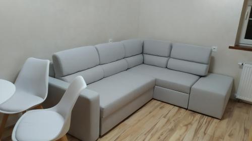 a white couch in a room with a table and chairs at Apartamenty U Iwony Centrum miasta blisko Parku Zdrojowego in Kudowa-Zdrój