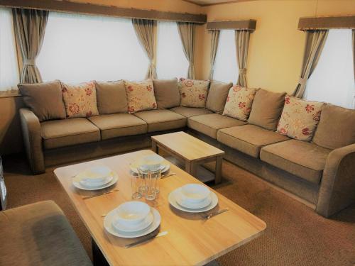 a living room with a couch and a table at Laurel Superior Holiday Home in Mablethorpe