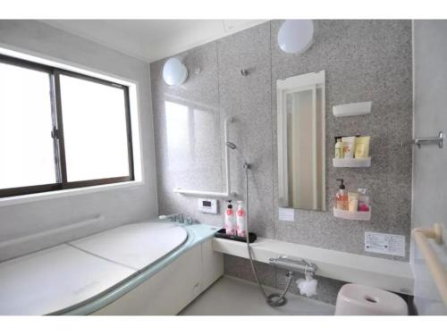 La salle de bains est pourvue d'une baignoire, d'un lavabo et d'un miroir. dans l'établissement Daichan Farm Guest House - Vacation STAY 19117v, 