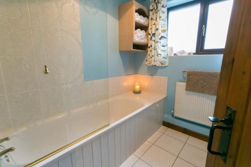 a bathroom with a bath tub with a candle in it at Erw Fach in Valley