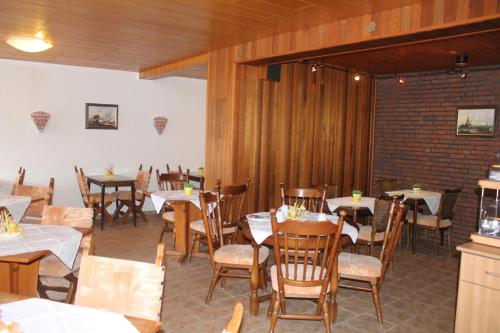 a restaurant with tables and chairs and a brick wall at Hotel Nordseegruß in Norddeich