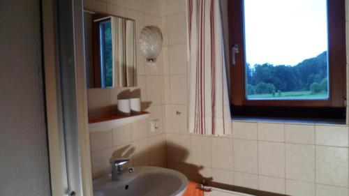 a bathroom with a sink and a window at Haus Auracher in Unterwössen