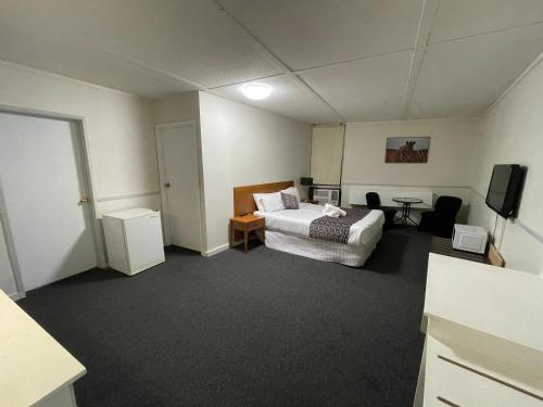 a hotel room with a bed and a television at Parkside Inn Motel in Melbourne