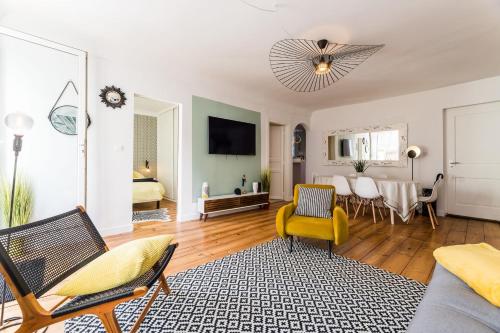 un salon avec une chaise jaune et un canapé dans l'établissement POP KEYWEEK Apt 3 bedrooms with terrace & parking Biarritz city center, à Biarritz