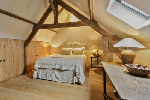 a bedroom with a bed and a wooden table at Loft Katelijne Luxurious Escape in the Heart of Historic Bruges in Bruges
