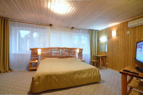 a bedroom with a bed and a flat screen tv at Akvareli Resort in Vereya