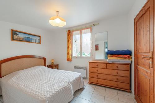 a bedroom with a bed and a dresser and a window at Maison charmante avec vue sur la mer à Paimpol in Paimpol