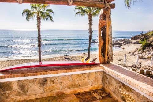 a surfboard sitting on a ledge next to the beach at Cabo Surf Hotel in San José del Cabo