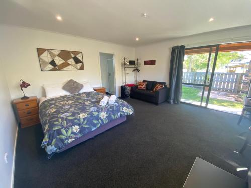 a bedroom with a bed and a couch at Star Cottages in Lake Tekapo