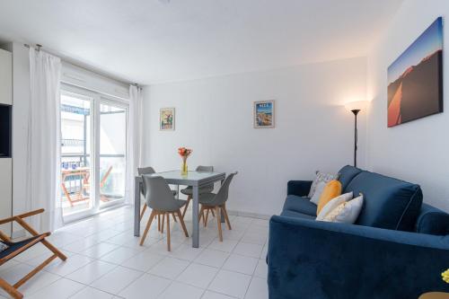 un salon avec un canapé bleu et une table dans l'établissement Comfortable 1 Bdr Downtown - AC & Parking, à Nice