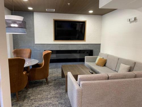 a living room with a couch and a table and a tv at Staybridge Suites Phoenix Glendale Sports Dist by IHG in Glendale