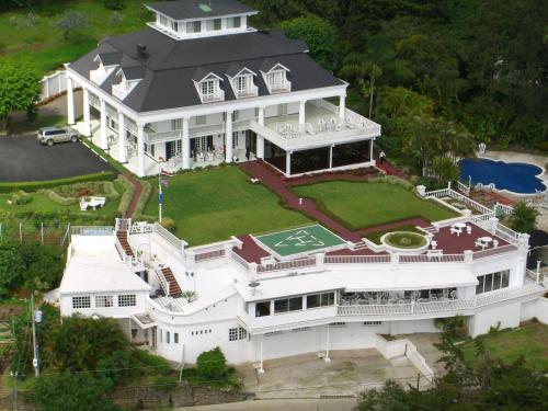 an aerial view of a large white house with a tennis court at Fogo Resort in Escazu